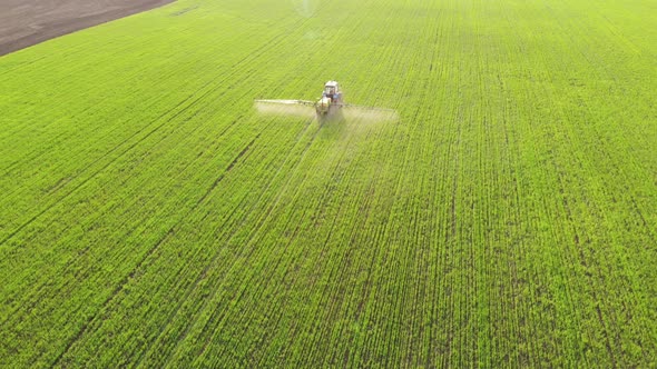 Aerial View of Farming Tractor Spraying on Field with Sprayer