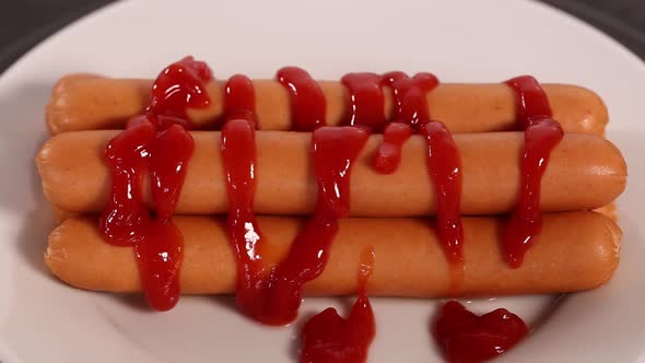 Pouring ketchup, mayonnaise and  parsley over sausages