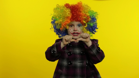 Little Child Girl Clown in Rainbow Wig Making Silly Faces. Having Fun, Smiling, Dancing. Halloween