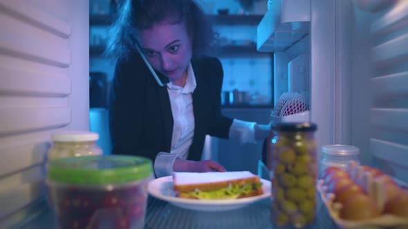 Businesswoman Talking on Cellphone Open Fridge and Take Sandwich for Snack