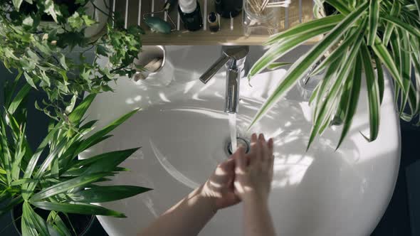 Woman Washing Hands in Bathroom