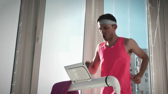 Cute guy runs on treadmill at home