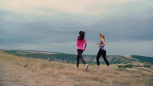 Two Slim Young Woman Jogging in Summer Park