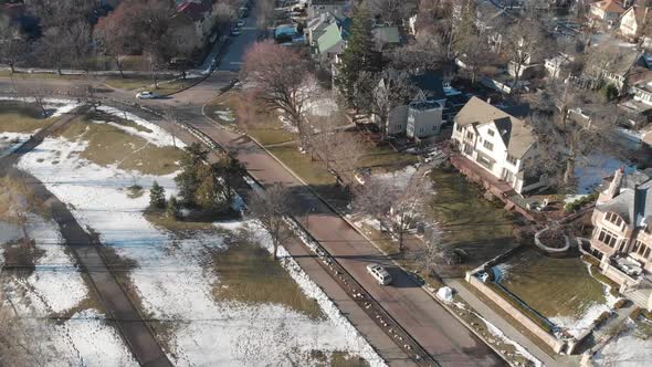 Aerial footage of suburbs in Minneapolis, cars going on a road by the lake shore