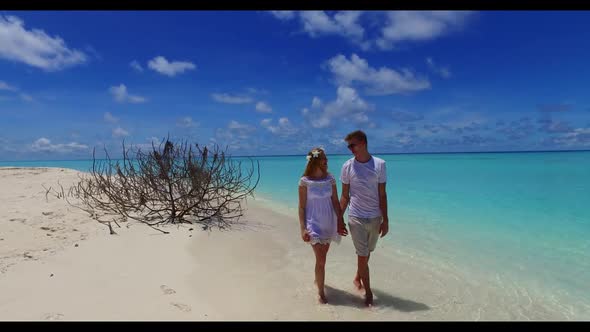 Family of two posing on tranquil shore beach trip by shallow ocean and clean sandy background of the