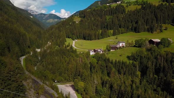 Village town at Dolomite mountains in northern Italy with the road passing through the hillside, Aer