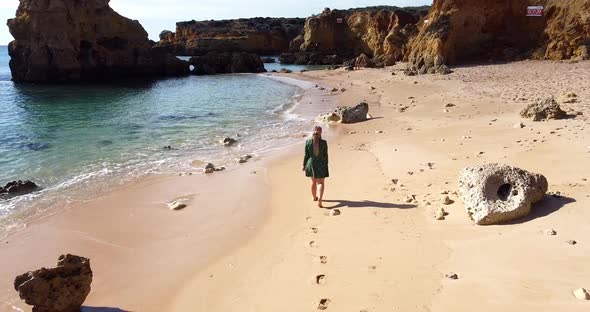 Woman in Beautiful Waving Dress Walking at the Empty Algarve Beach