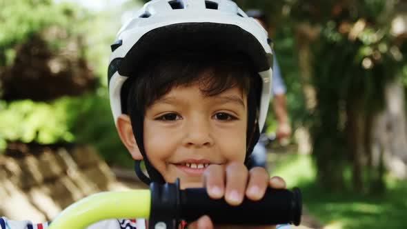 Portrait of smiling boy wearing bicycle helmet in park