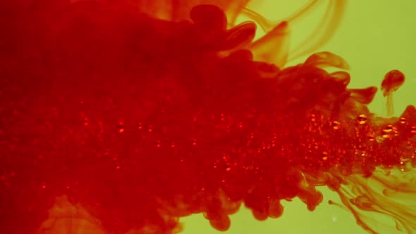 Bloody Red Load of Ink Flushing Into Sparkling Water Over Yellow Background in Slowmotion