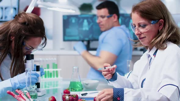 Female Bio Researcher Injecting GMO Into Strawberries