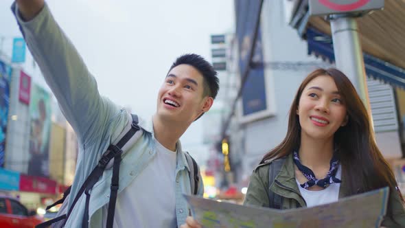 Asian active young couple travel in city for honeymoon trip at night.