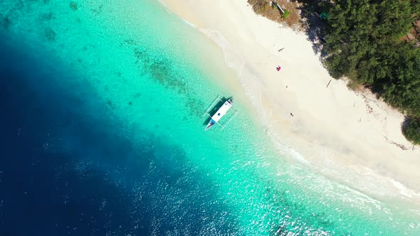 Natural flying travel shot of a paradise sunny white sand beach and turquoise sea background in colo