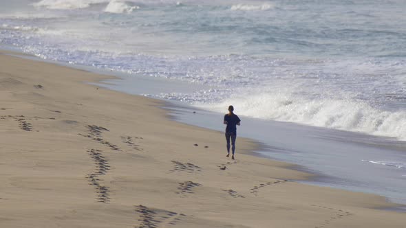 A woman jogs on the beach