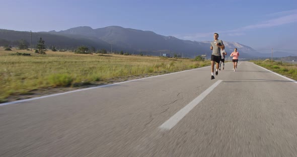 Tracking Slow Motion Shot of Sportive Couple Jogging Outdoors in the Morning Trail Running