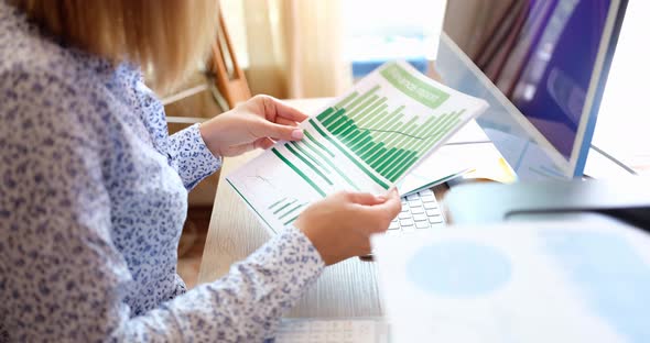 A Woman in the Office Looks at the Company's Financial Report