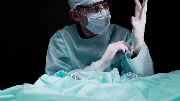 Surgeon Puts Sterile Gloves on His Hands During Surgery and Prepares for Surgery