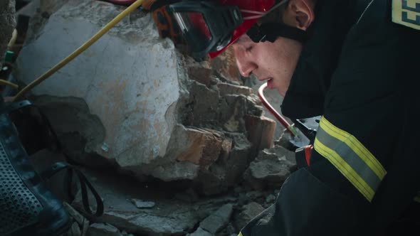 Male Rescuer Examining Rubble and Talking