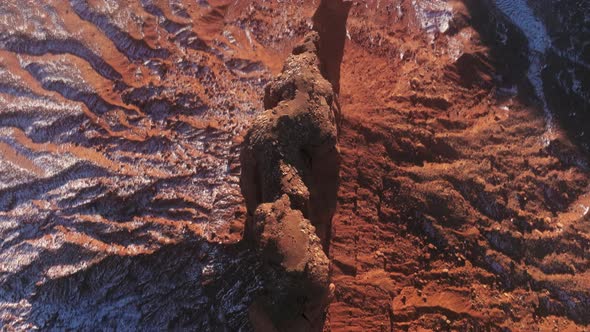 Top Down Narrow and Tall Red Cliffs Rising High at Red Desert Covered By Snow