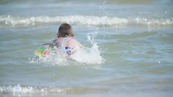 a Boy with a Circle Swims