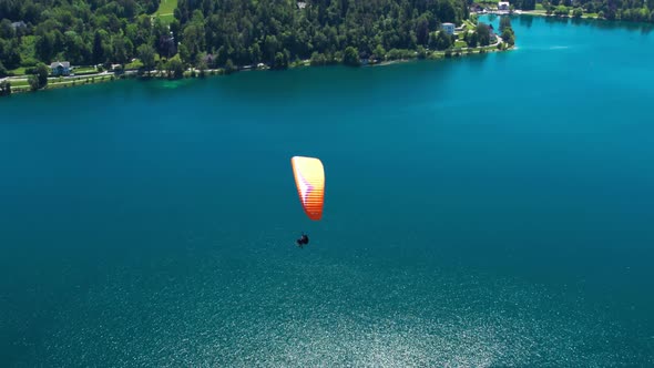 Aerial View Of Paraglider Soaring Above Waters Of Lake Bled In Slovenia. Orbit Motion