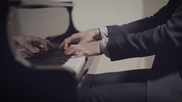 Male pianist performing a song on piano with low light and shallow depth of field with slider motion