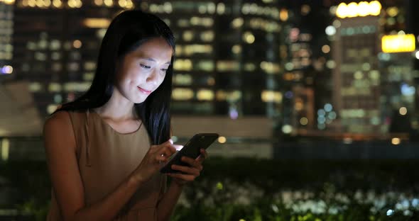 Woman looking at mobile phone in city 