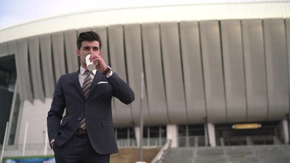 Businessman drinking coffee outside the office