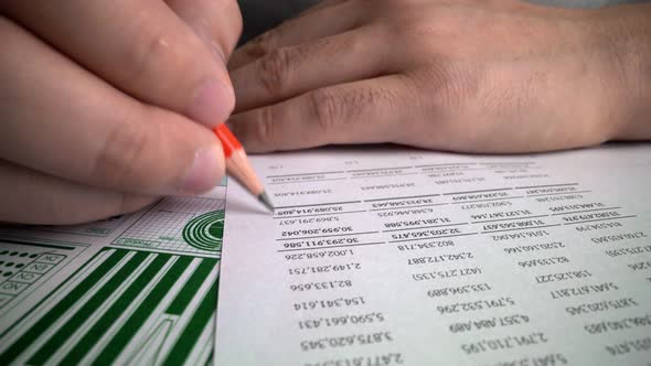 Accountant analyzing business marketing data on paper dashboard at office table.