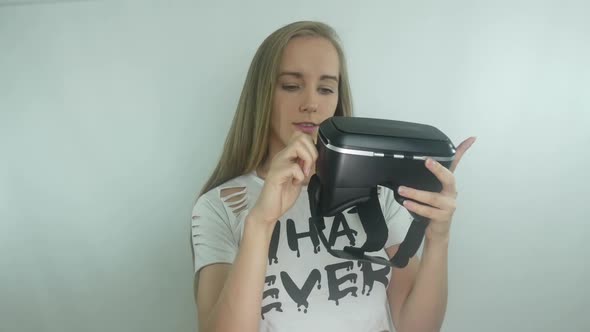 Young Girl Examines A Virtual Reality Helmet