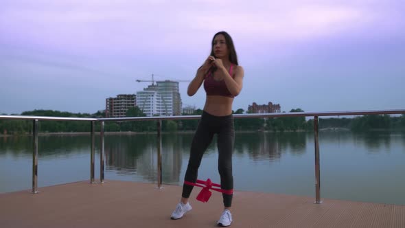 Fitness Woman Doing Squats on Lake Pier