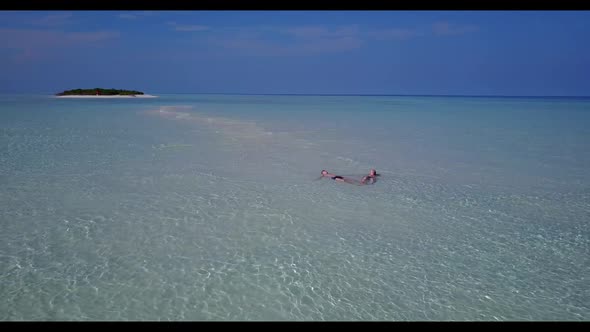 Man and lady engaged on relaxing resort beach voyage by blue sea with white sand background of the M