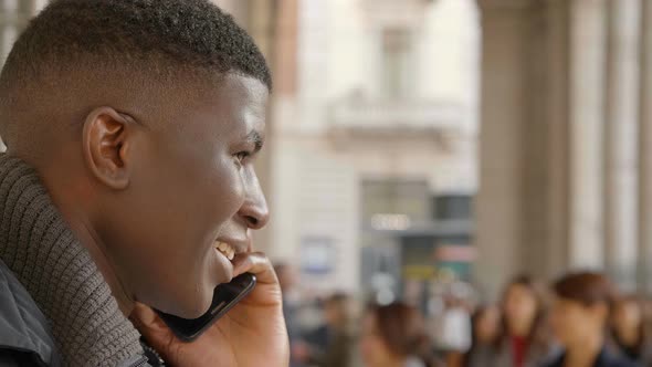 young black businessman at phone in the crowded street