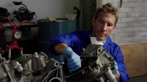 Male mechanic repairing motorbike parts in repair garage 4k