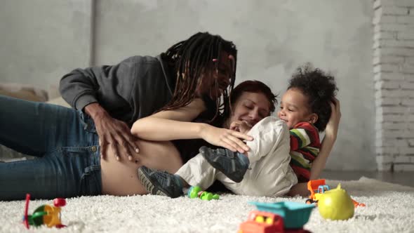 Interracial Family with Child Playing on the Floor alt
