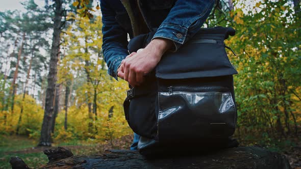 Close Up Shot of Tourist Putting Thermos Into Backpack and Keep Walking in Autumn Forest