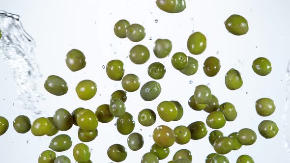 Super Slow Motion Shot of Flying Olives and Water Side Splash at 1000 Fps