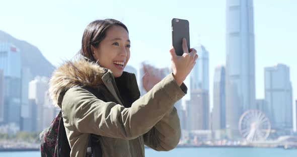 Woman taking video call on cellphone in Hong Kong city