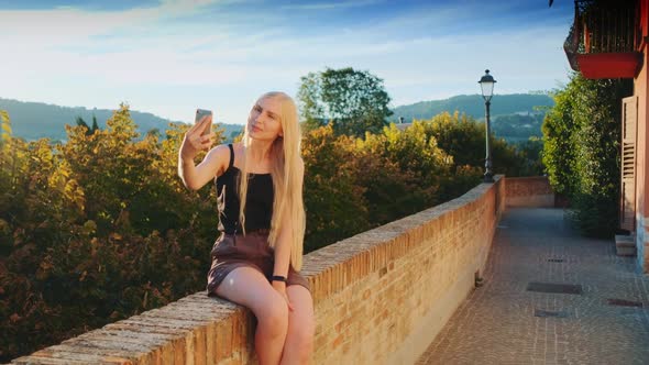 Pretty Lady Making Selfie on Smartphone in Front of Beautiful Nature Landscape