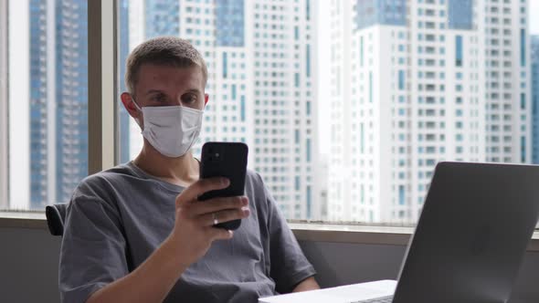 Business Man in a Face Mask Working From Home During Covid19 Pandemic