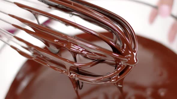 Close Up Delicious Dark Melted Chocolate on Whisk Pouring in Bowl, Slow Motion