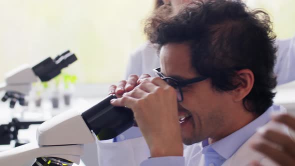 Scientists with Microscopes Working in Laboratory