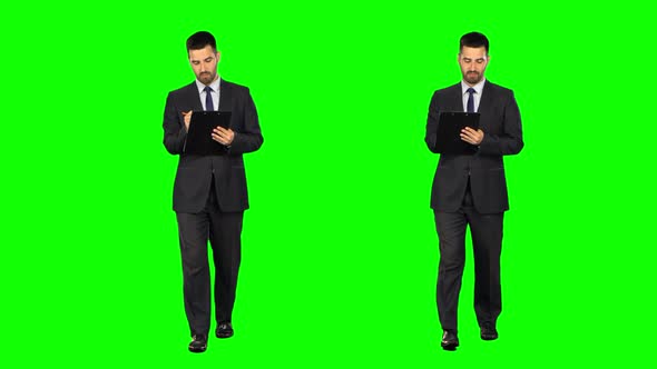 Businessman with a Tablet Walks on Green Screen. Two Takes.