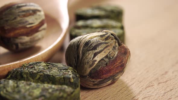 Green tea round balls with flowers with jasmine. In a wooden spoon and on a cutting board