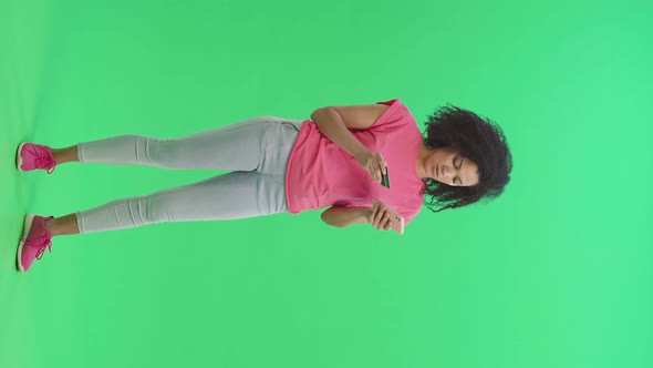 Portrait of Young Female African American Makes an Online Purchase Using Credit Card and Phone