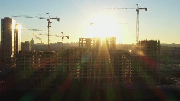 Several Construction Tower Cranes in the Process of Building Houses in a New Residential Complex at