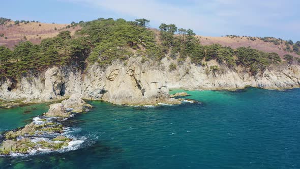 Aerial View of the Rocky Seashore of a Beautiful Bay with Transparent Water