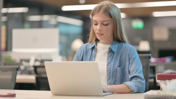 Young Woman Working on Laptop in Office