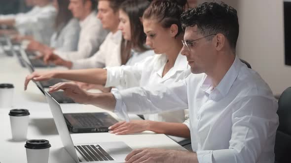 Employees Synchronously Opens a Laptops