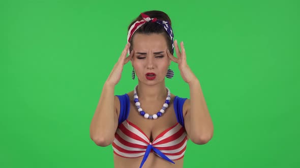 Portrait of Beautiful Girl in a Swimsuit Is Suffering From Headache From Fatigue. Green Screen