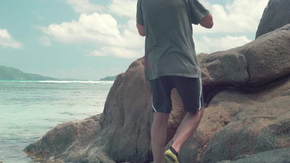 Legs of Unrecognizable Man Walking on Stone in the Sea